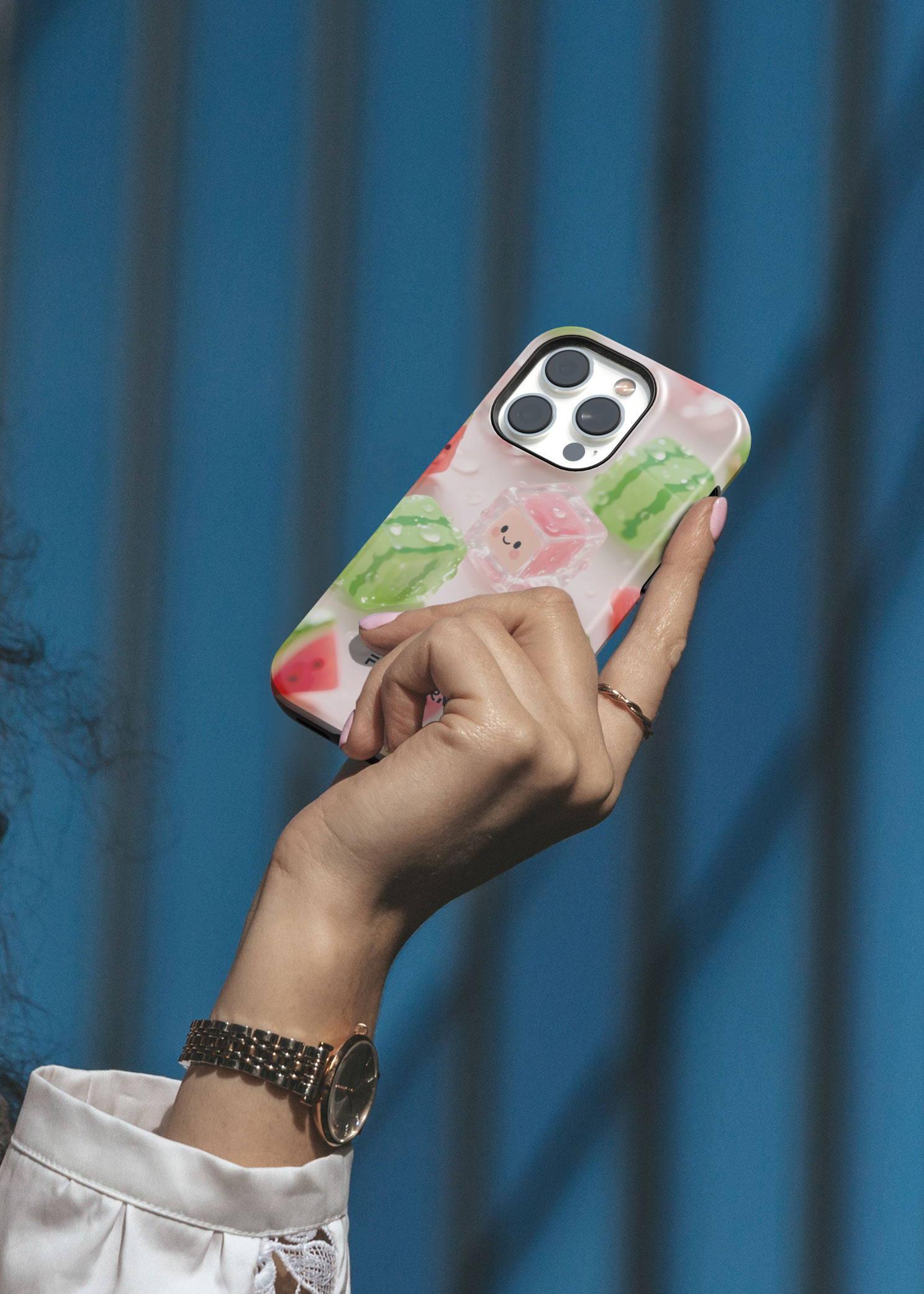 Hand holding a phone with a floral case against a blue curtain background
